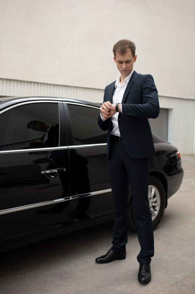 Chauffeur standing by a Black Label Limousines car